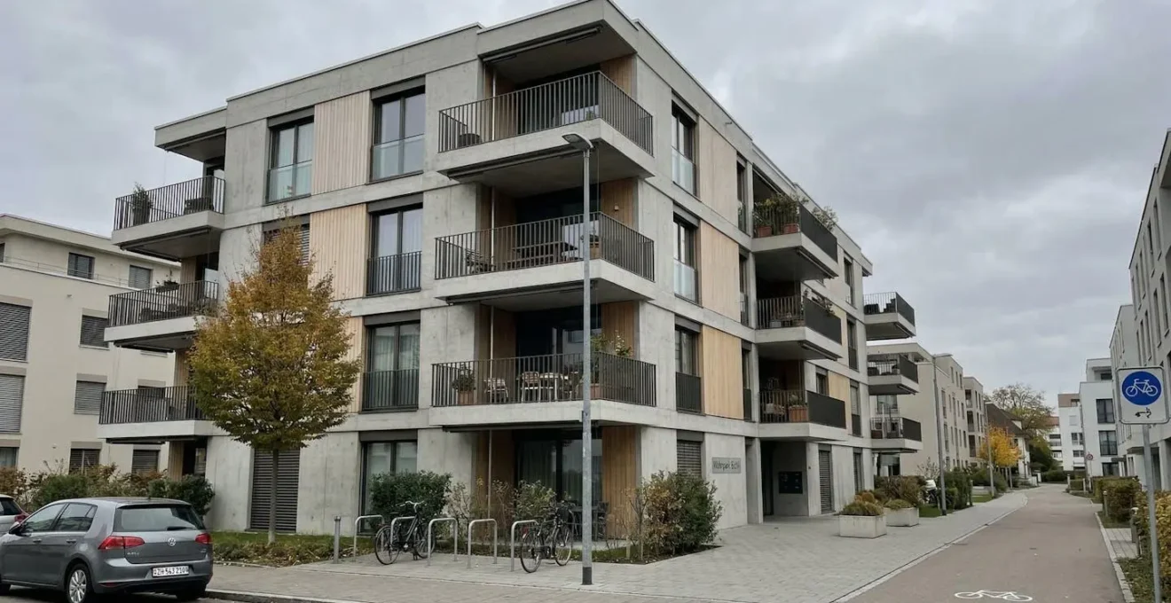 Modernes Mehrfamilienhaus mit zeitgenössischer Architektur in einer Schweizer Stadt bei bewölktem Tageslicht